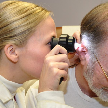 doctor looking at patient's ear